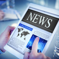 Potpourri man reading the news on a digital tablet