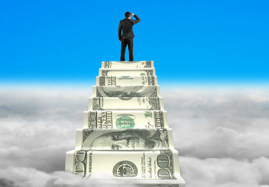 businessman reaching the top of money stairs