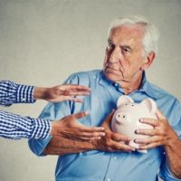 TRUST FUNDS elderly man clutching piggy bank