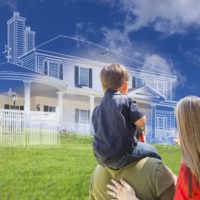 young family facing ghosted house drawing, partial photo and rolling green hills.