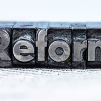 the word "reform" in lead letters written
