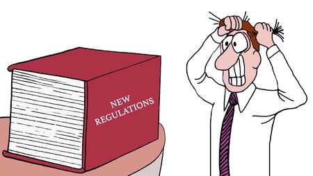 cartoon of a businessman pulling his hair out as he sees a huge book of new regulations.