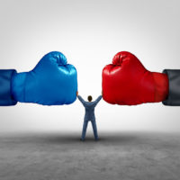 mediate and legal mediation business concept as a businessman or person separating two boxing glove opposing competitors as an arbitration success symbol for finding common interests to lawfully solve a conflict.