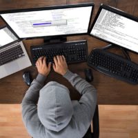 high angle view of hacker stealing information from computers at desk