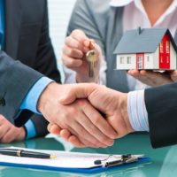 estate agent shaking hands with customer after contract signature