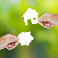 hand holding paper piggy bank and house shape new house buy concept