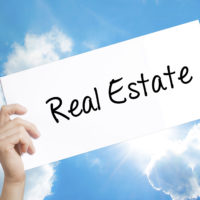 Last Chance for Real Estate License Prep Classes 75553693 - man hand holding paper with text real estate . sign on white paper. isolated on sky background. business concept. stock photo