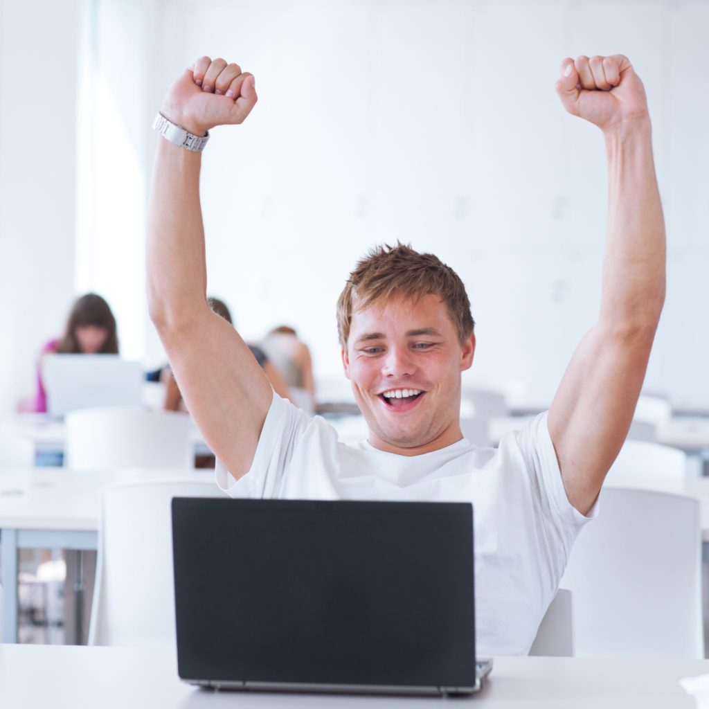 student with arms up in success