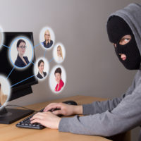 masked thief stealing data from computers