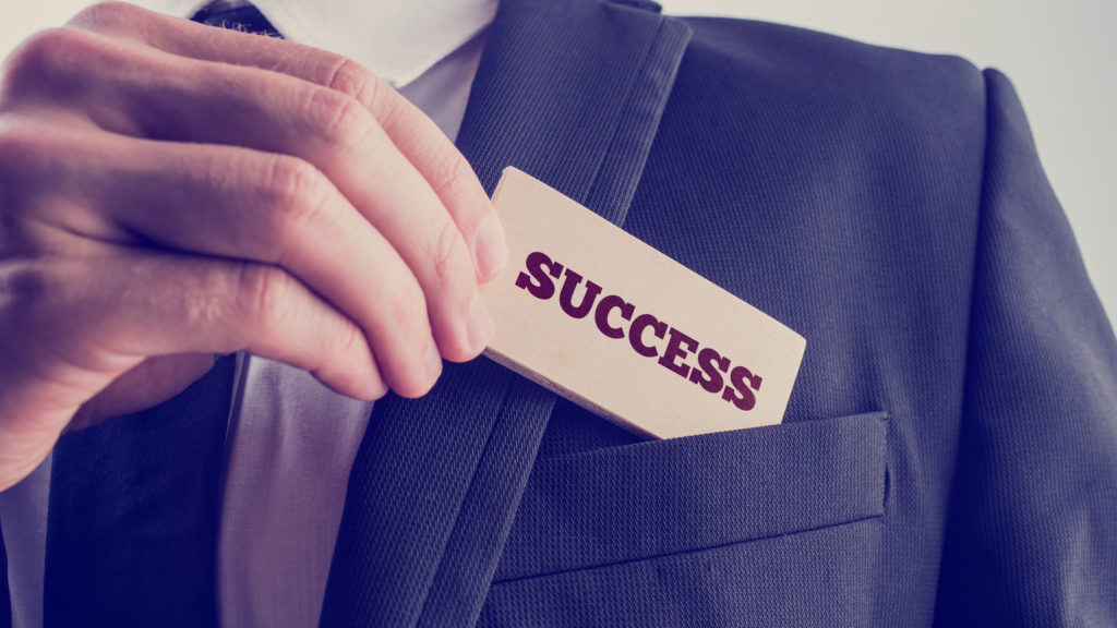 Successful businessman showing a card - Success