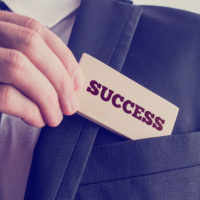 Successful businessman showing a card - Success