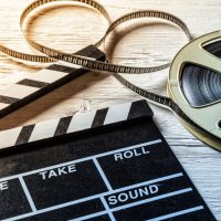 Film camera chalkboard and roll on wooden table