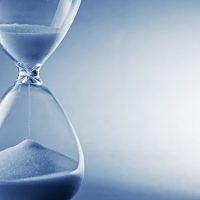 41722506 - closeup hourglass clock on light blue background