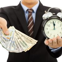 businessman holding money and clock. time is money concept