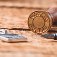 67960754 - notary public wax stamper on old wooden background