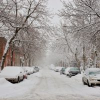 The street filled with fresh snow during a snow storm