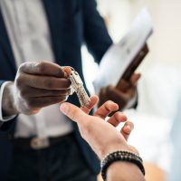 Real estate agent handing the house key to a client