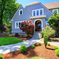 American craftsman house exterior. View of entry door and porch with concrete stairs. Nice landscape design around. Northwest, USA