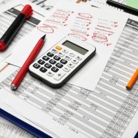 Top view of office worker's desk - work with financial reports, analysis and accounting, tables and graphs, various office items for bookkeeping