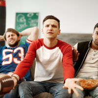 Disappointed football fans watching match in disbelief