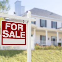 33134132 - home for sale real estate sign in front of beautiful new house.